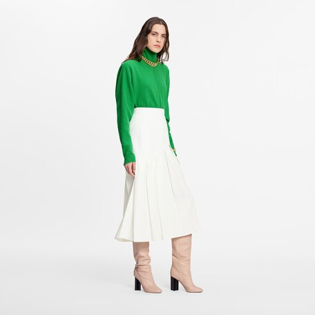 Falda blanca plisada, con botines. Foto: Louisvuitton